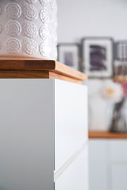 Nahaufnahme eines weißen Möbelstücks mit Holzplatte, seitliche Perspektive