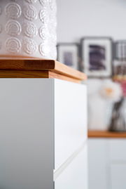 Nahaufnahme eines weißen Möbelstücks mit Holzplatte, seitliche Perspektive