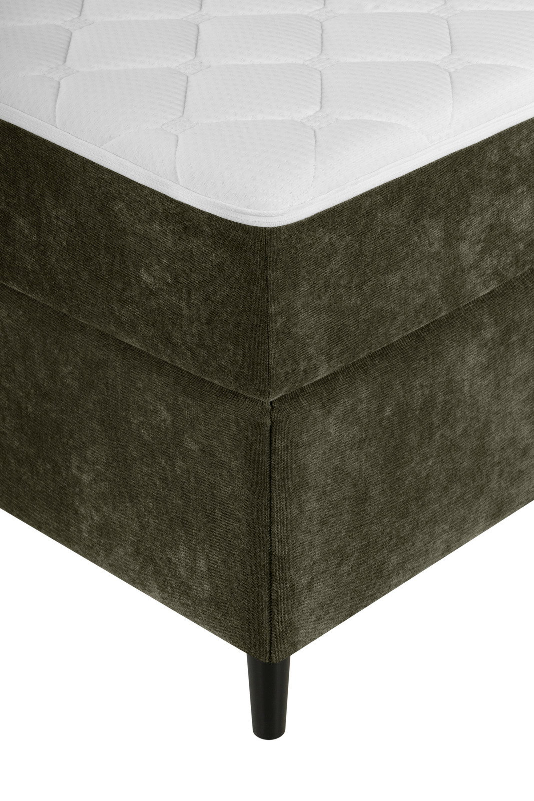 Ecke eines Boxbetts mit dunkelgrünem Stoffbezug und schwarzem Bein, aus der Perspektive von unten links.