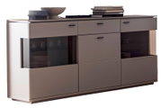 Modernes Sideboard in Grau mit abgerundeten Ecken, zwei getönten Glas-Schiebetüren und Schubladen, mit Deko auf der Deckplatte, in frontaler Ansicht leicht von links fotografiert.