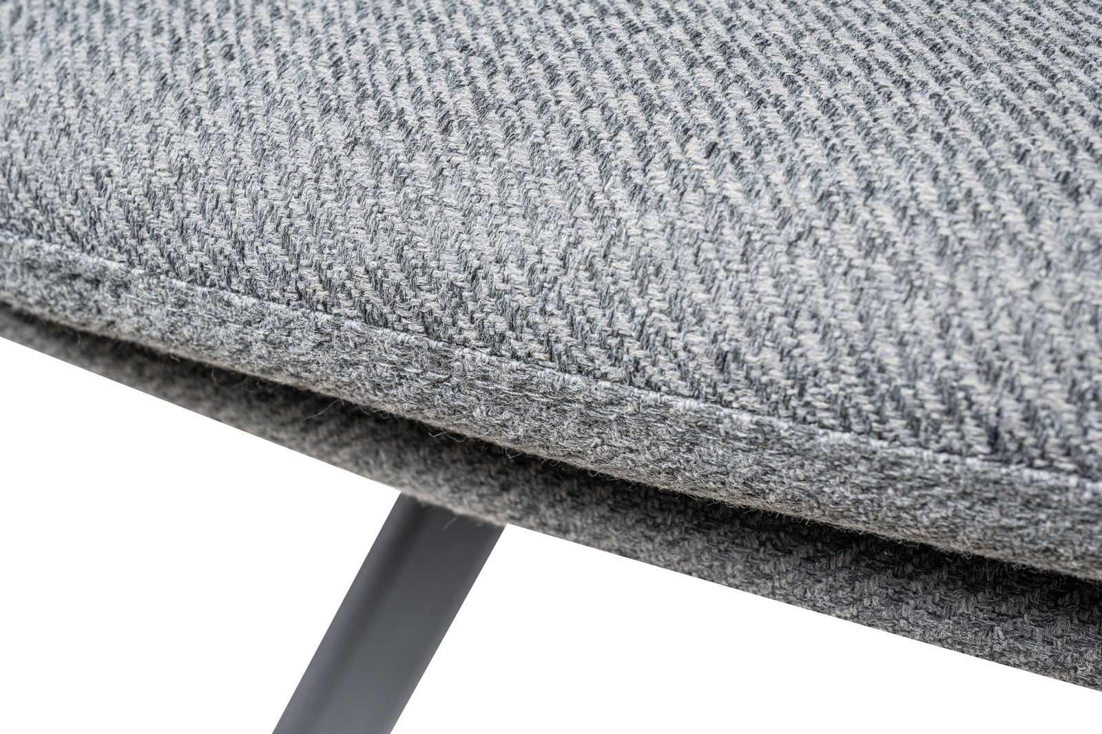 Nahaufnahme eines grauen Sessels mit strukturiertem Stoffbezug und Metallbeinen, seitliche Perspektive.