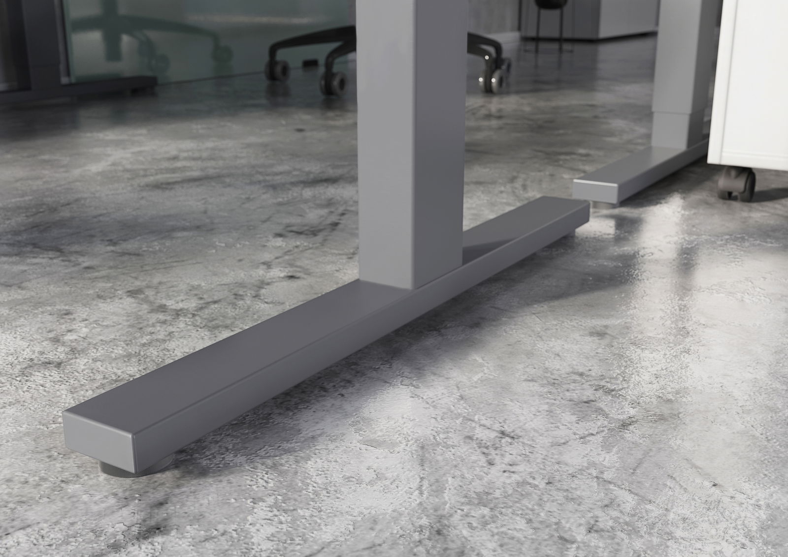 Nahaufnahme der stabilen Metallfüße eines E-Schreibtisches auf einem Betonboden, seitliche Perspektive.