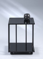 Schwarzer Beistelltisch mit Glasoberfläche, darauf ein dekoratives Teelicht, frontal fotografiert.