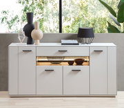 Modernes weißes Sideboard mit dekorativen Vasen und Lampe, frontal fotografiert.