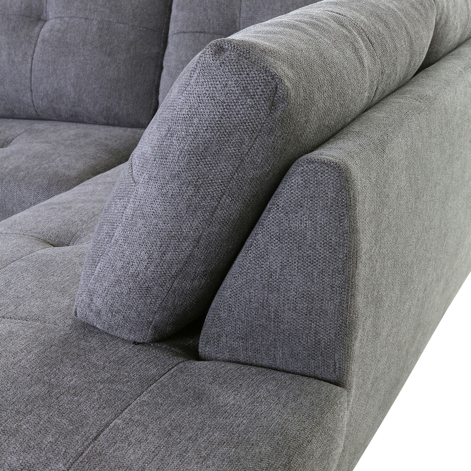Nahaufnahme einer grauen Sofaecke mit gepolsterten Kissen, seitliche Perspektive.