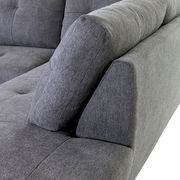 Nahaufnahme einer grauen Sofaecke mit gepolsterten Kissen, seitliche Perspektive.