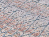 Nahaufnahme eines Designer-Teppichs mit geometrischem Muster in Pastelltönen, schräg von der Seite fotografiert.