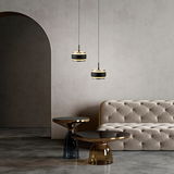 Zwei moderne LED-Pendelleuchten in einem eleganten Raum mit einem beigen Sofa und stilvollen Beistelltischen, seitliche Perspektive.