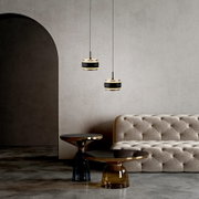 Twee moderne LED-hanglampen in een elegante ruimte met een beige bank en stijlvolle bijzettafels, gezien vanaf de zijkant.
