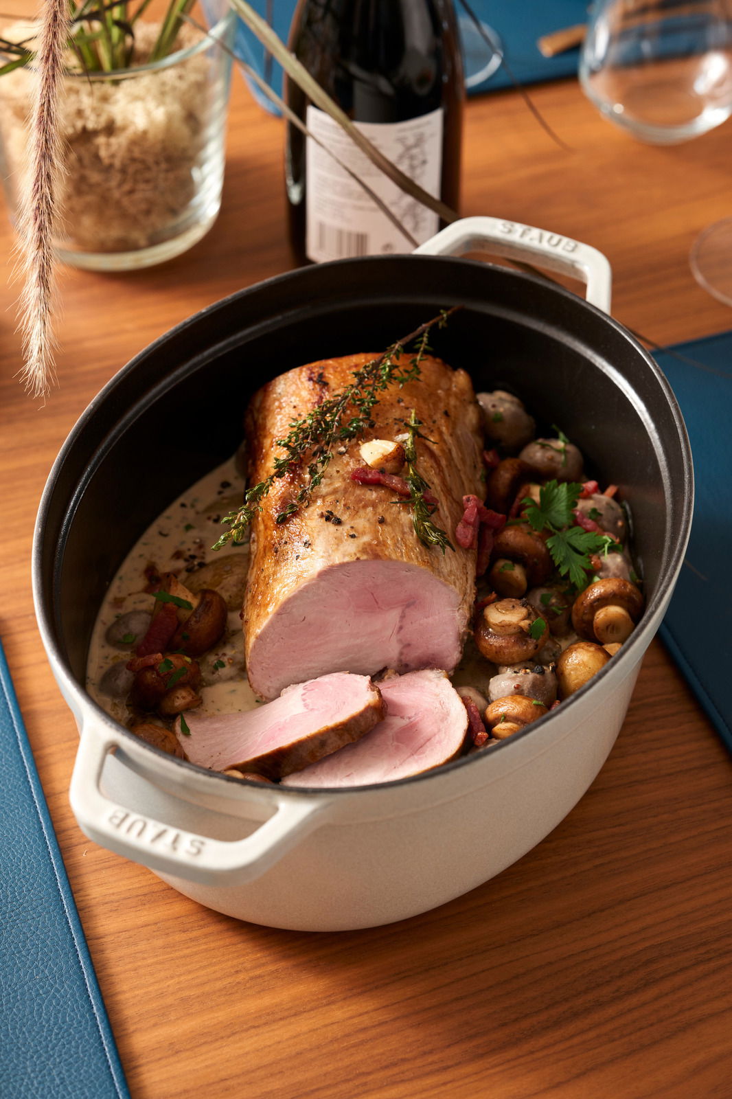 Ovale Cocotte 33cm mit gebratenem Fleisch, Pilzen und Kräutern, von oben fotografiert.