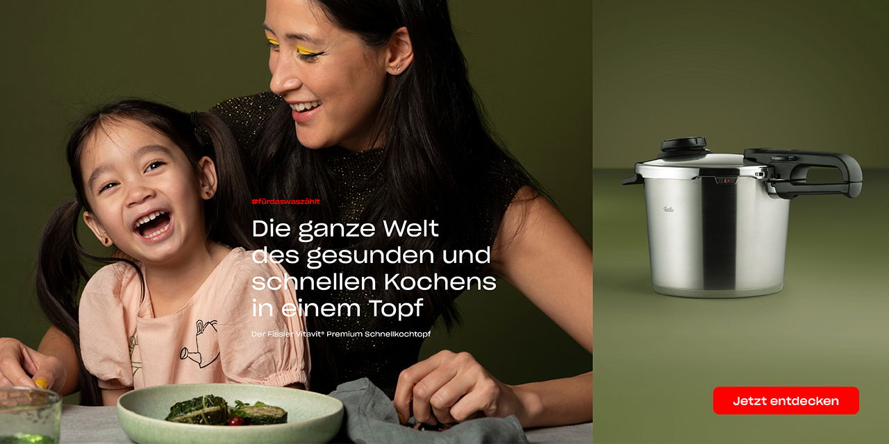 Eine Frau und ein Mädchen sitzen an einem Tisch. Daneben das Bild eines Schnellkochtopfs und ein Werbetext in deutscher Sprache.