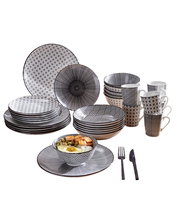 Kombiservice Tokyo 30-teilig, schwarz-weißes Geschirrset mit geometrischen Mustern, auf einem Holztisch in einer modernen Küche präsentiert, seitliche Perspektive.