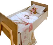 Kinderbett mit Holzrahmen, Bettwäsche mit Feenmotiv und Puppe, Perspektive von schräg oben