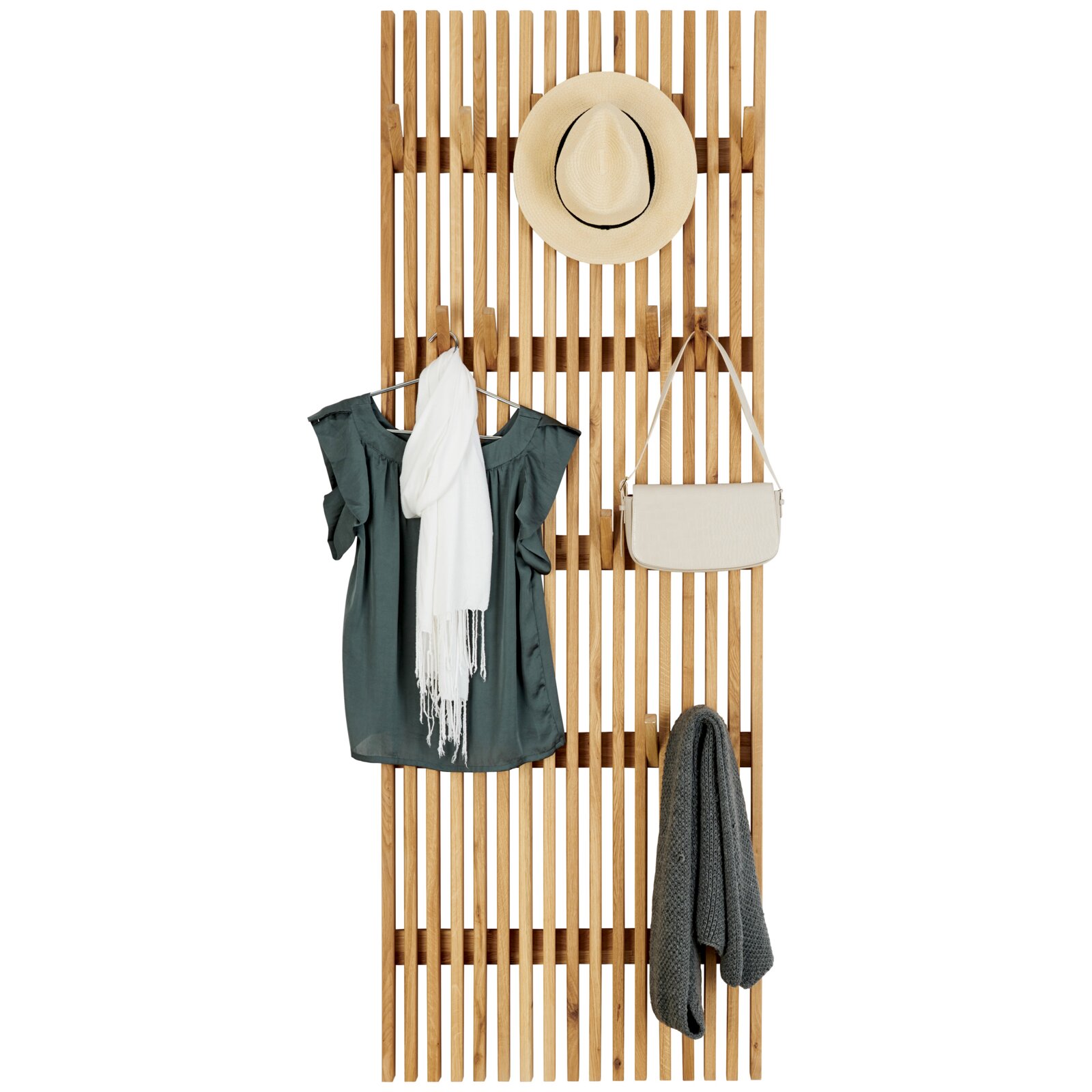 Holz-Garderobenpaneel aus senkrechten Lamellen mit Haken, daran Hut, Kleid, Schal, Handtasche und Strickjacke, frontal von vorn auf weißem Hintergrund