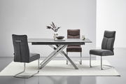 Moderner Essbereich mit einem rechteckigen Tisch und drei Freischwinger-Stühlen in verschiedenen Grautönen, seitliche Perspektive.