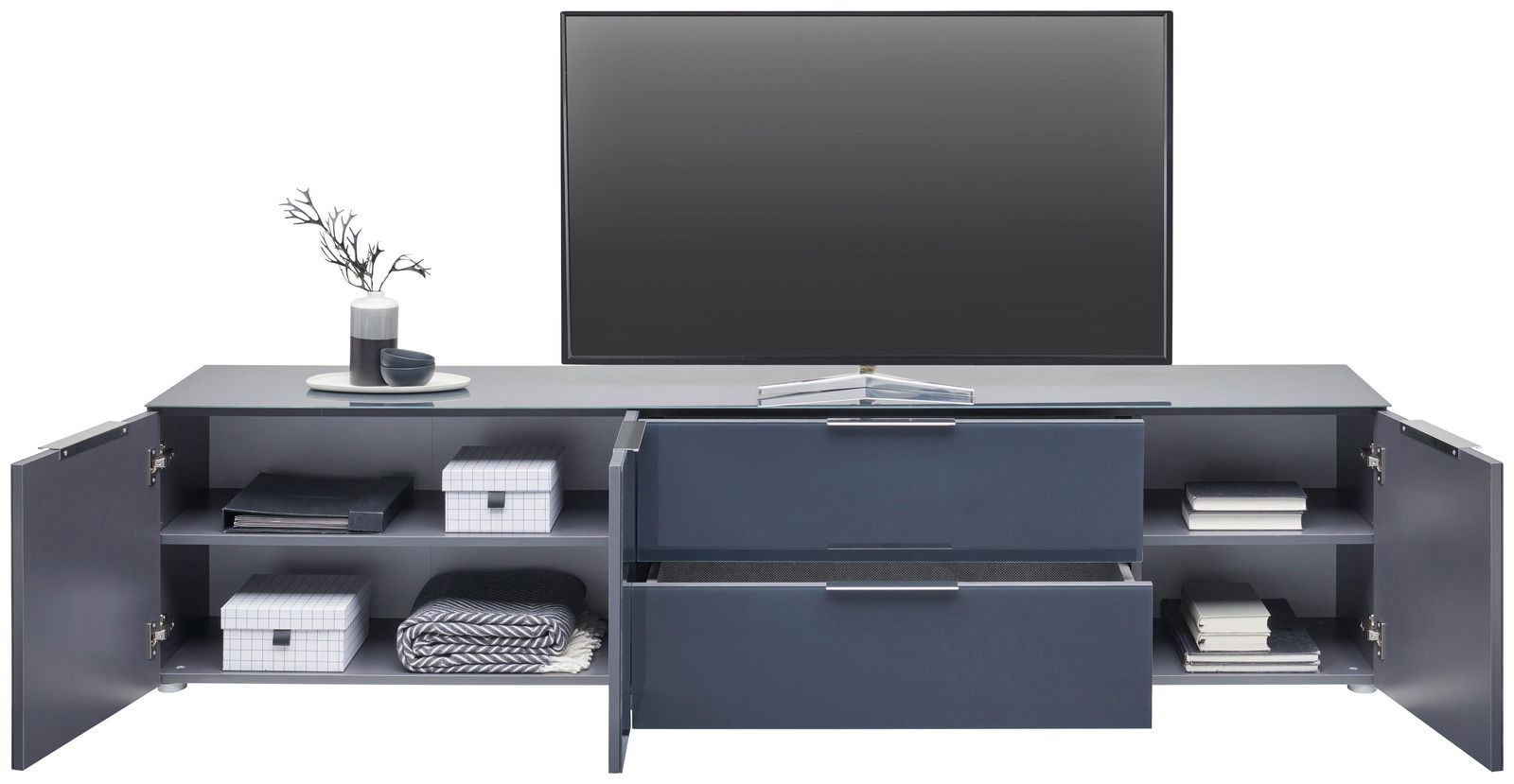 Frontale Ansicht eines XL-TV-Lowboards mit offenen Schubladen und Türen, dekoriert mit Vasen und Büchern.