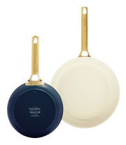 Zwei Bratpfannen in den Größen 20 cm und 26 cm, eine mit heller Innenfläche und goldfarbenem Griff, die andere mit dunkler Unterseite und goldfarbenem Griff, aus der Vogelperspektive.