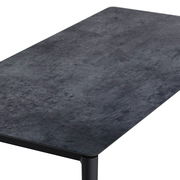 Moderner Loungetisch mit dunkler, steinartiger Oberfläche, aus schräger Perspektive fotografiert.