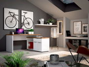 Moderner Eckschreibtisch in einem stilvollen Arbeitszimmer mit Dekorationen, Pflanzen und einem Laptop, aus der Perspektive von vorne links betrachtet.