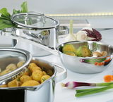 Topf-Set FINESSE2+ 5-teilig aus Edelstahl, gefüllt mit frischem Gemüse und Kartoffeln, in einer modernen Küchenumgebung, seitliche Perspektive