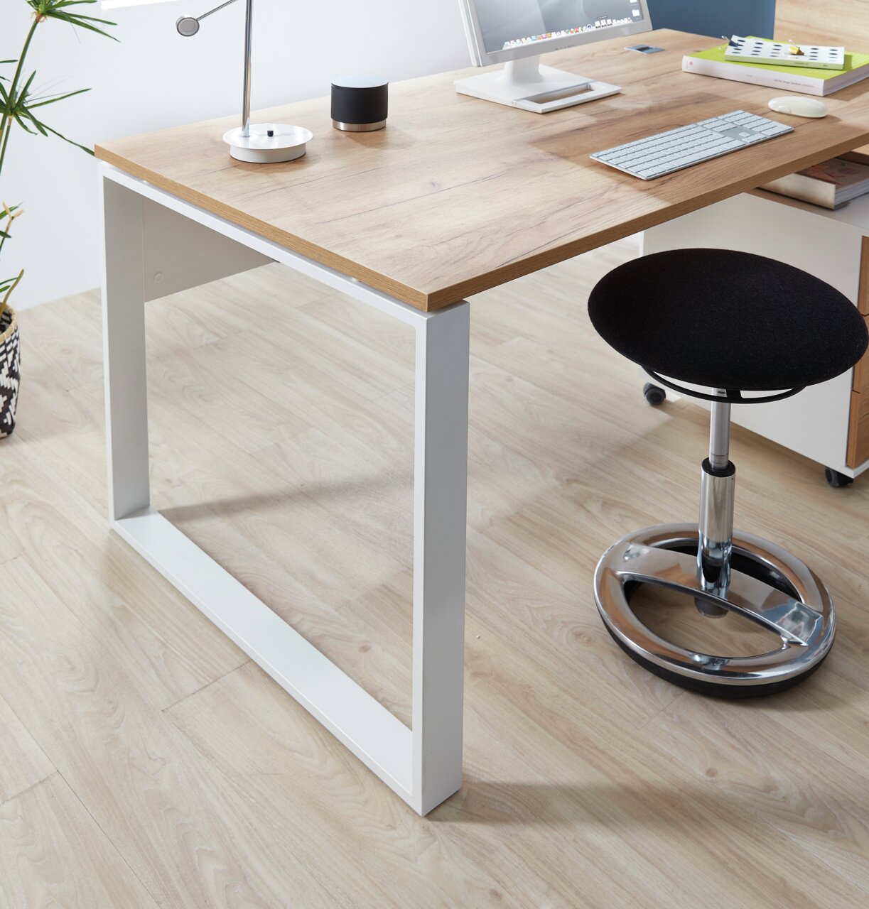 Moderner Schreibtisch mit Holzplatte und weißen Metallbeinen, seitliche Perspektive