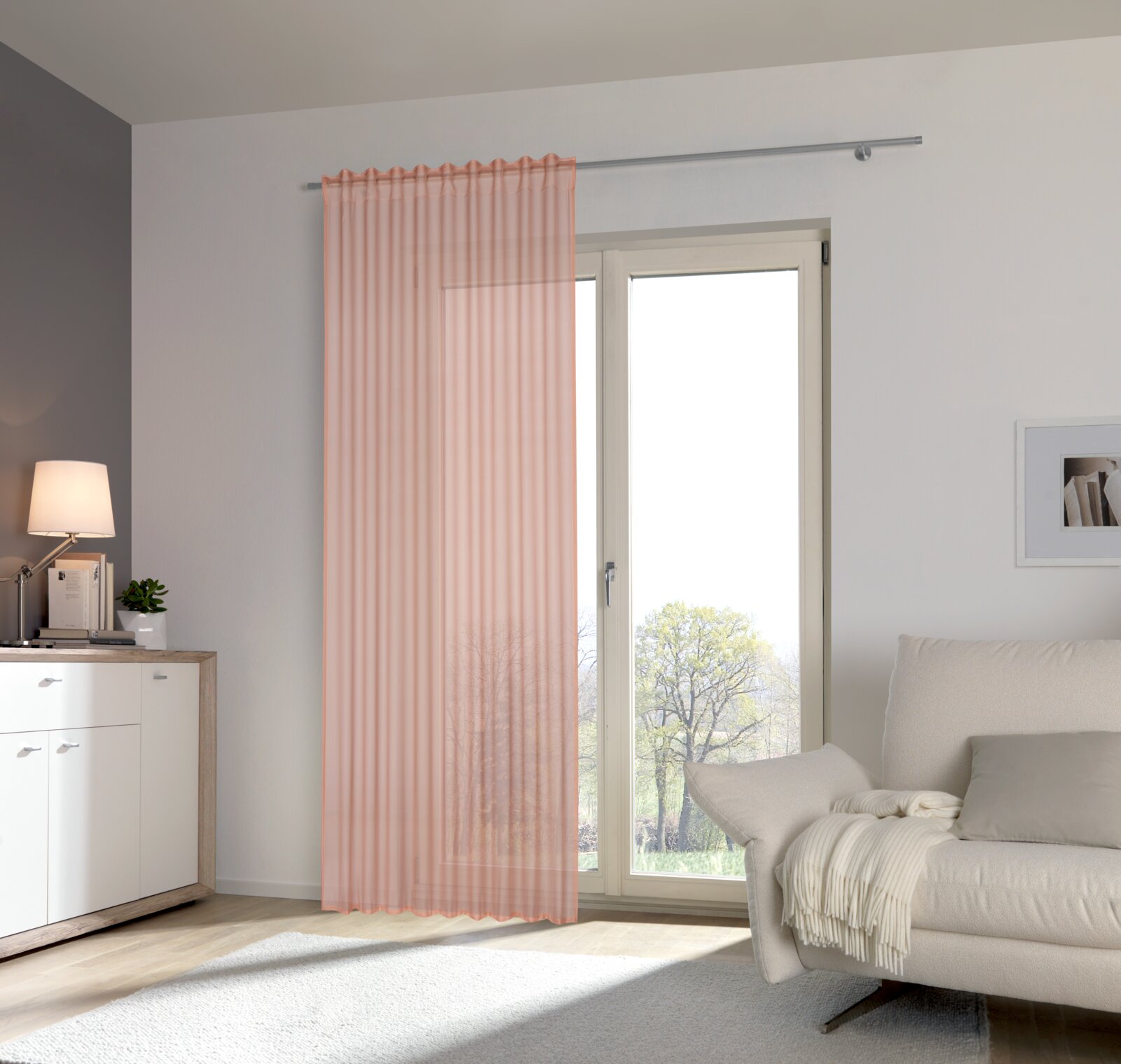 Kant-en-klaar gordijn Nora in een moderne woonkamer, opgehangen voor een grote raampartij met uitzicht naar buiten.