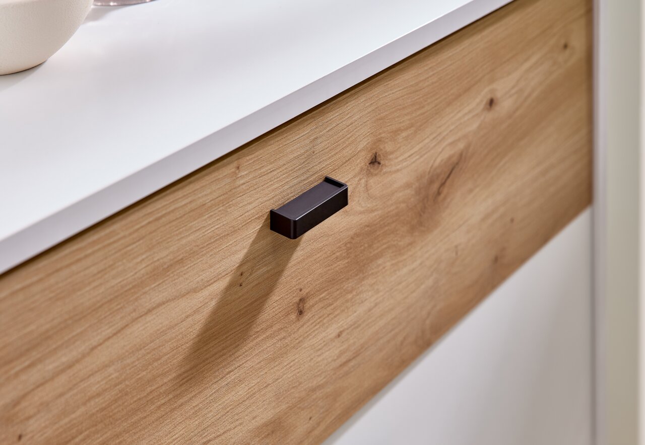 Nahaufnahme einer Kompaktgarderobe mit Holzoptik und schwarzem Griff, seitliche Perspektive