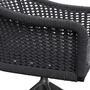 Detailansicht eines Armlehnstuhls mit geflochtenem Seilgewebe in dunkler Farbe, von hinten betrachtet.