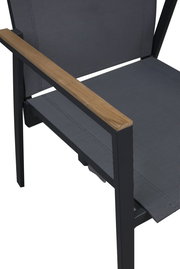 Nahaufnahme eines Stapelstuhls mit schwarzem Metallrahmen und Armlehnen aus Holz, seitliche Perspektive