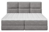Frontale Ansicht eines grauen Boxspringbetts mit gepolstertem Kopfteil und weißer Matratze.