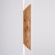 LED-Wandleuchte aus Holz in seitlicher Perspektive mit warmem Lichtschein nach oben und unten.