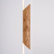 LED-Wandleuchte aus Holz in seitlicher Perspektive mit warmem Lichtschein nach oben und unten.