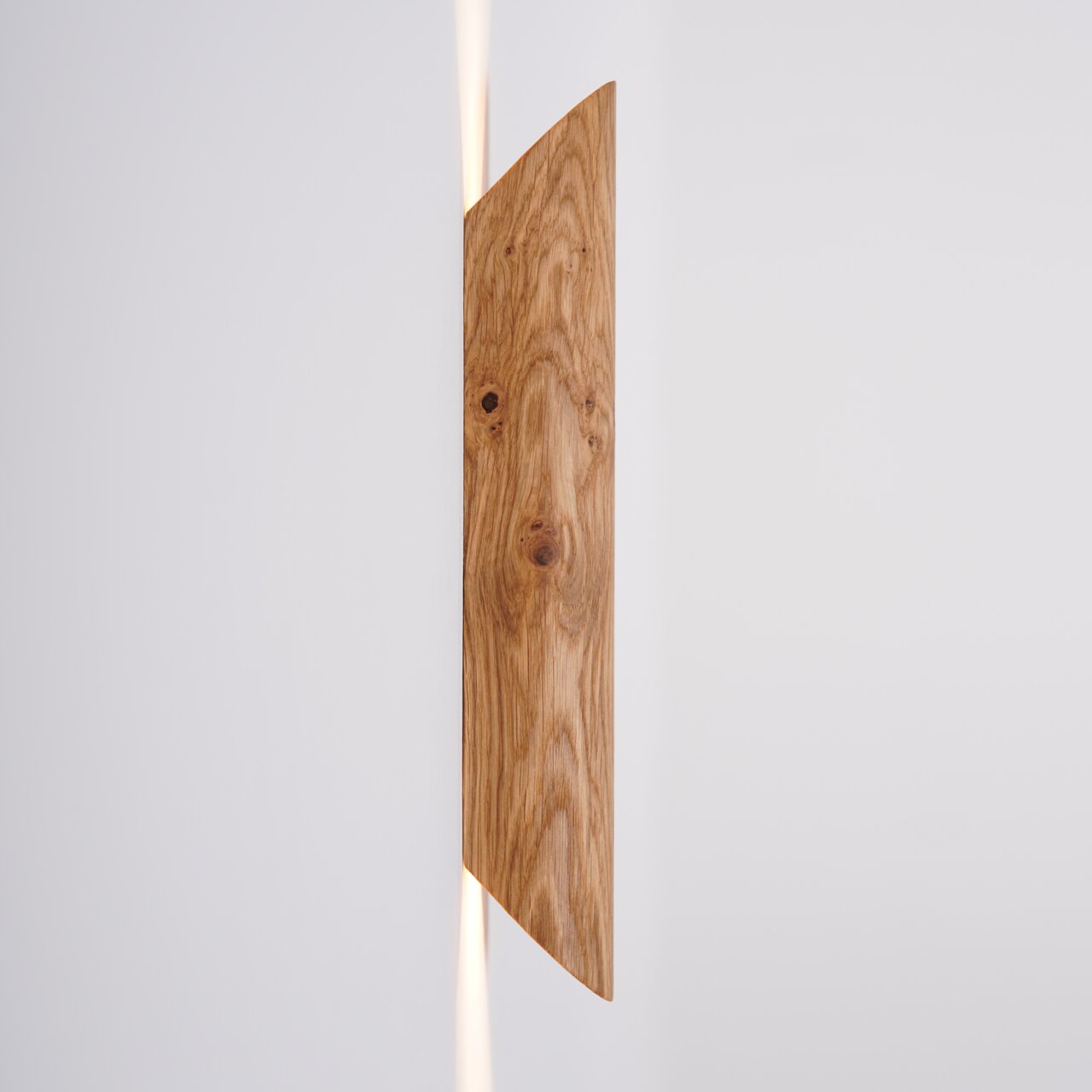 LED-Wandleuchte aus Holz in seitlicher Perspektive mit warmem Lichtschein nach oben und unten.