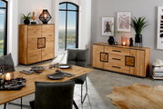 Modernes Esszimmer mit Sideboard und Highboard aus hellem Massivholz mit schwarzen Akzenten, aufgenommen in schräger Frontansicht im Raum.