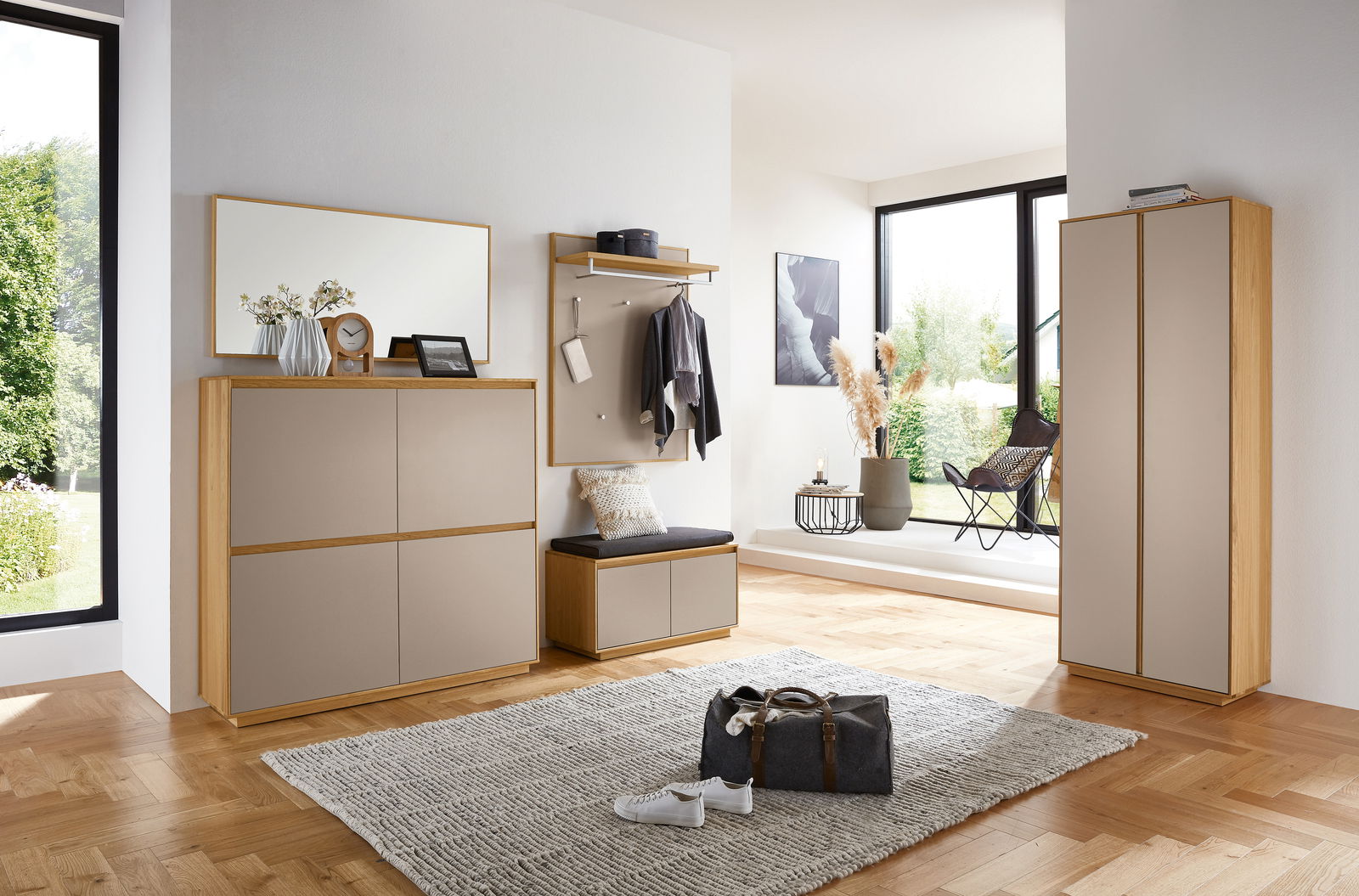 Moderne Garderobeneinrichtung mit Spiegel, Schuhschrank, Garderobenbank und Garderobenpaneel in einem hellen Raum mit Holzfußboden, seitliche Perspektive.