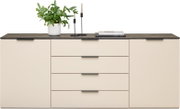 Modernes Sideboard in Cremefarbe mit vier Schubladen und zwei Türen, dekoriert mit einer Pflanze, Kerzenhaltern und Büchern, aus frontaler Perspektive.