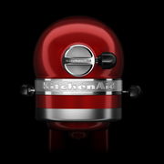 Rote Küchenmaschine von hinten mit silbernem Logo und schwarzem Hintergrund