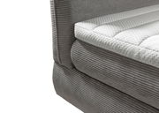 Nahaufnahme eines grauen Boxspringbetts mit gestepptem weißen Topper, seitliche Perspektive