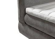 Nahaufnahme eines grauen Boxspringbetts mit gestepptem weißen Topper, seitliche Perspektive