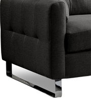 Detailaufnahme eines dunkelgrauen Stoffsofas mit gesteppter Polsterung und glänzendem Metallkufenfuß, Perspektive schräg von vorne/seitlich