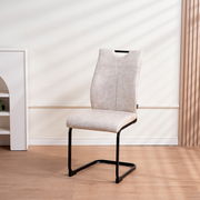 Moderner Schwingstuhl mit beigem Polster und schwarzem Metallgestell, seitliche Perspektive