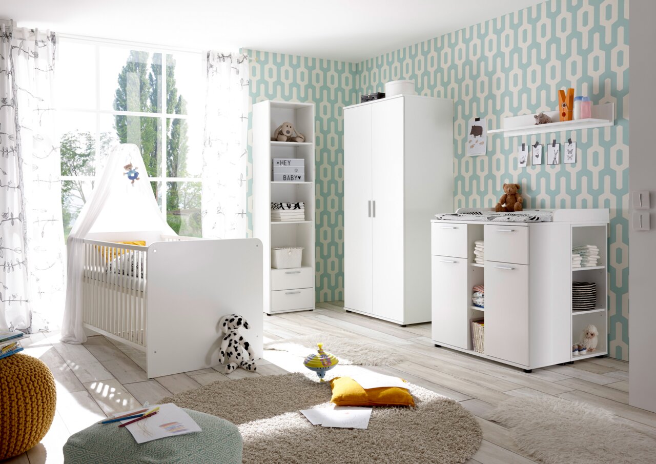Helles Kinderzimmer mit weißem Gitterbett, Wickelkommode und Schrank in moderner Einrichtung, seitliche Perspektive.