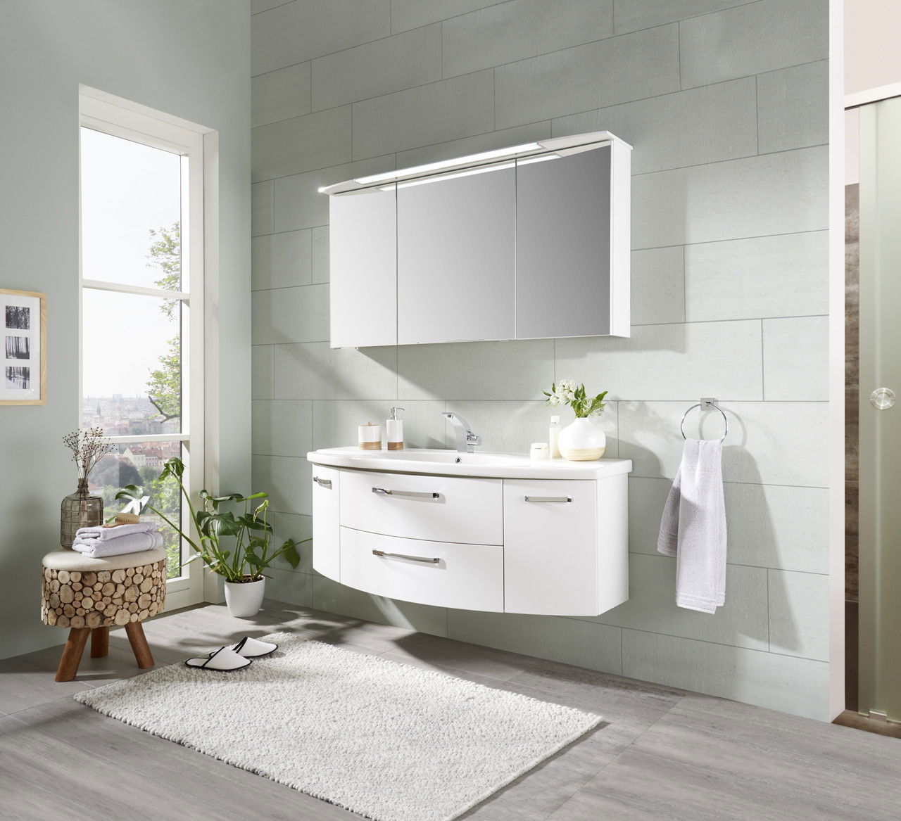 Moderne Badkombination mit weißem, wandhängendem Waschtisch und Spiegelschrank, seitliche Perspektive