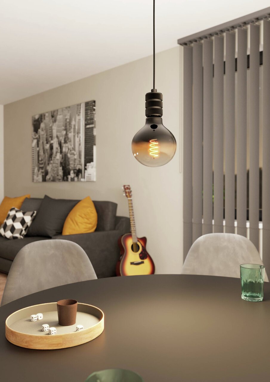 Moderne Pendelleuchte YORTH mit sichtbarem Glühfaden, hängend über einem Tisch in einem stilvoll eingerichteten Wohnzimmer, seitliche Perspektive.