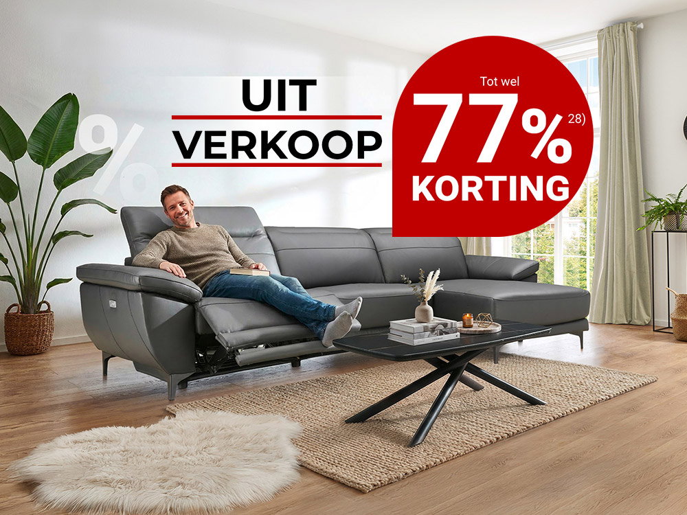 Man ontspant op grijze leren bank in woonkamer, uitverkoop met tot 77% korting.