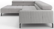 Lichtgrijze ribcord hoekbank met chaise longue links en brede armleuning rechts, op zwarte metalen poten; zijaanzicht schuin van voren.
