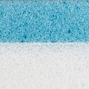 Nahaufnahme eines zweischichtigen Matratzentoppers mit einer weißen und einer blauen Schicht, die die Struktur und Textur des Materials zeigt.