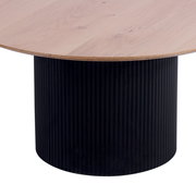 Runder Couchtisch mit heller Holzplatte und schwarzem, geripptem Zylindersockel, seitliche Perspektive