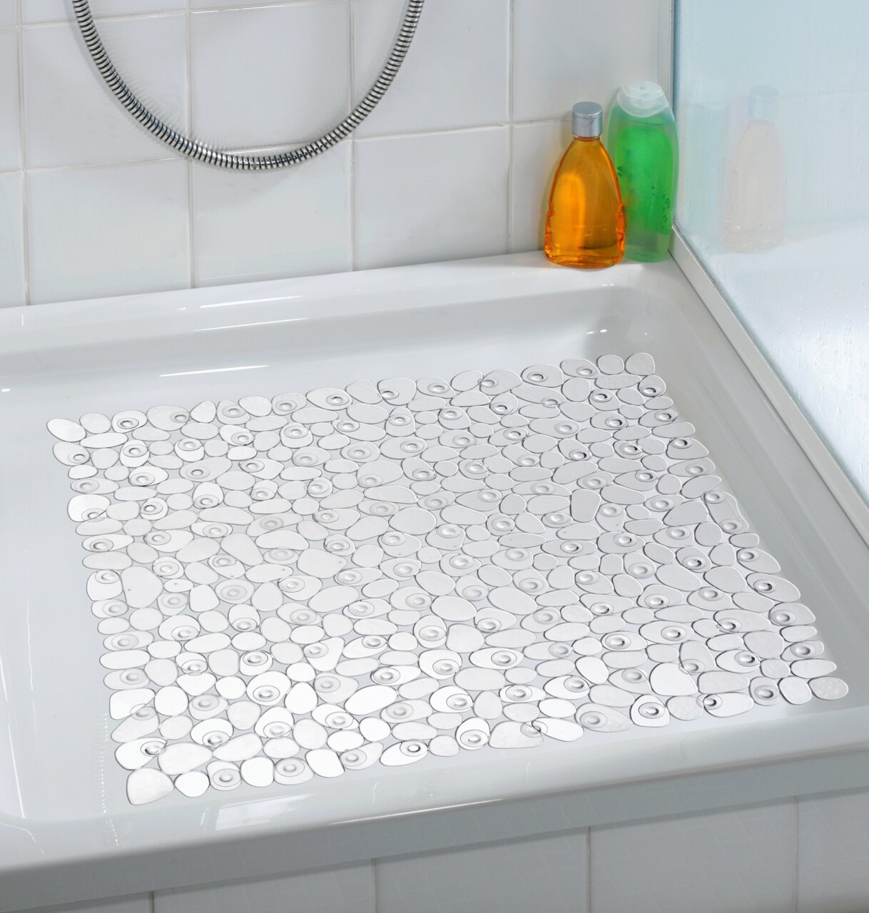 Transparente Duscheinlage mit Kieselsteinmuster in einer Duschwanne, seitliche Perspektive