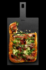 Schneidebrett mit Griff, darauf eine Pizza mit Schinken, Rucola und Oliven, aus der Vogelperspektive fotografiert.